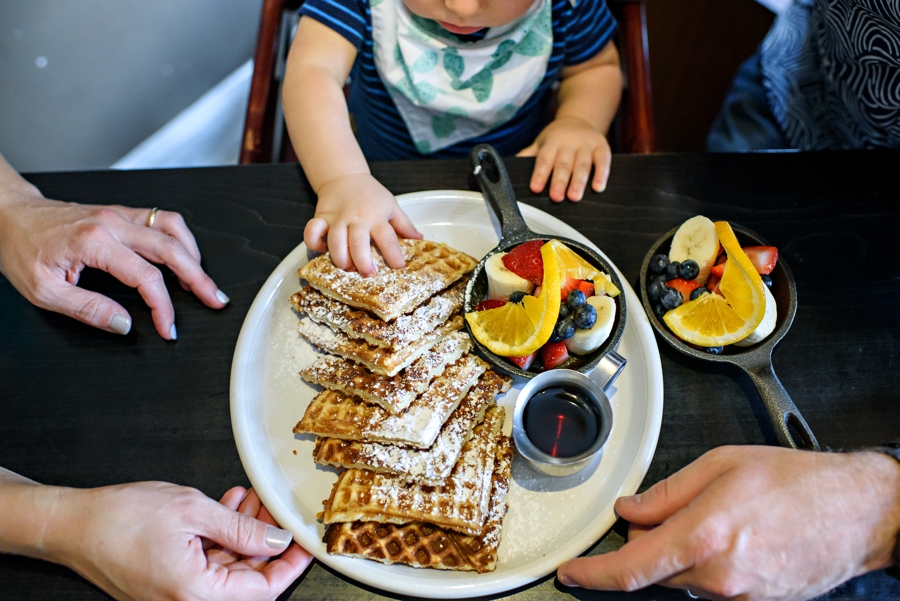 A baby getting to eat his first waffle.